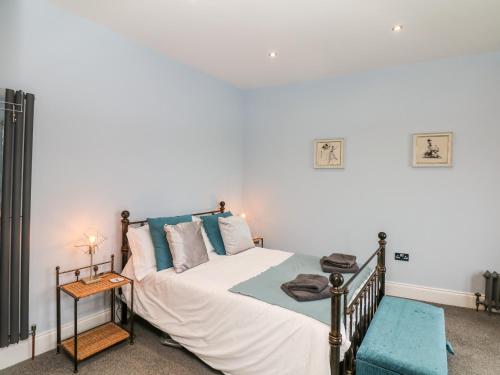 a bedroom with a bed with white sheets and blue pillows at The Dolphins in Shaldon