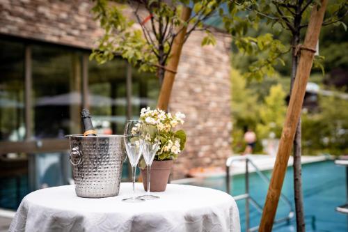 a table with a bottle of champagne and flowers on it at Himmelchalet - Alpencamping Nenzing in Nenzing