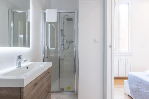 a white bathroom with a shower and a sink at Garisenda, Bologna by Short Holidays in Bologna