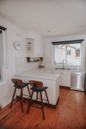 a kitchen with two chairs and a counter and a sink at Coastaways in Port Campbell