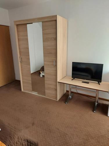 a room with a tv and a desk with a mirror at Zajazd Promyk 