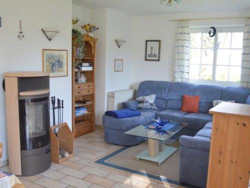 a living room with a blue couch and a fireplace at Fanö Huset in Boren