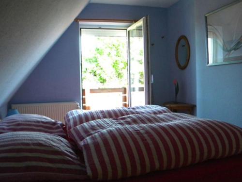 a bed in a blue room with a window at Fanö Huset in Boren