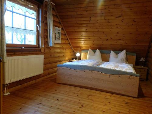 a bedroom with a bed in a log cabin at Block Hus in Hasselberg