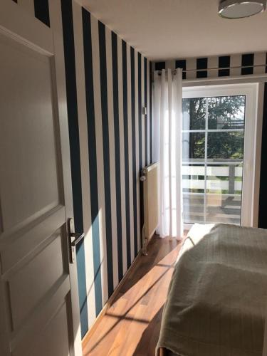 a bedroom with a bed and a striped wall at Haus Sina in Boren