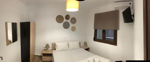 a bedroom with a white bed and a window at MAD'S Villas in Néa Péramos