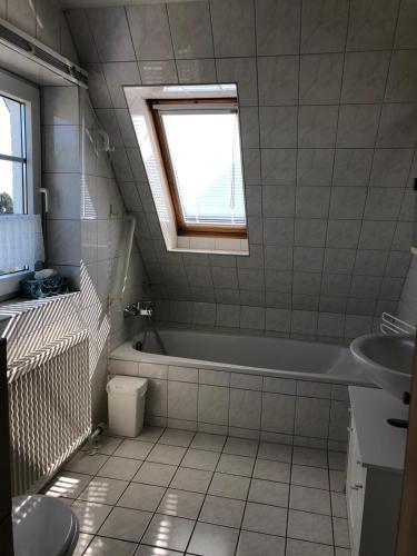a bathroom with a tub and a sink and a window at Penaten in Boren