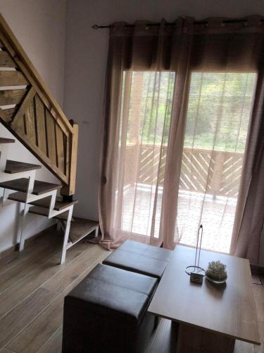 a living room with a table and a large window at MAD'S Villas in Néa Péramos