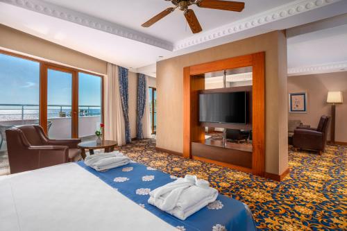 a hotel room with a bed and a flat screen tv at Bera Alanya Hotel - Halal All Inclusive in Konaklı