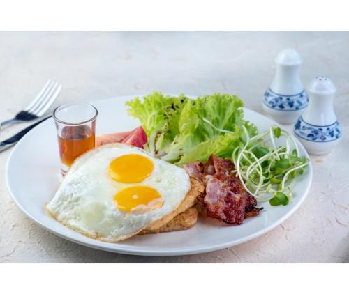 a plate of breakfast food with an egg and a salad at Nirvana Beach Resort, Koh Lanta SHA Extra Plus in Ko Lanta