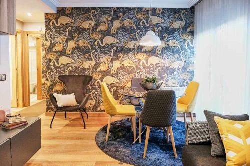 a living room with chairs and a wall with a mural at Apartamento Mariscal in Pontevedra
