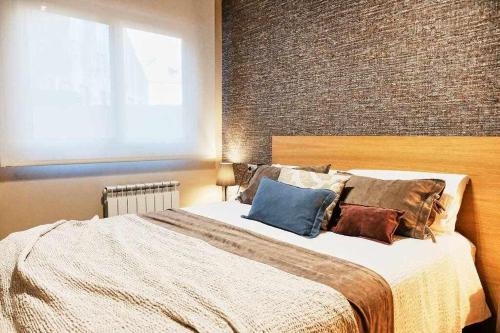 a bedroom with a large bed and a brick wall at Apartamento Mariscal in Pontevedra