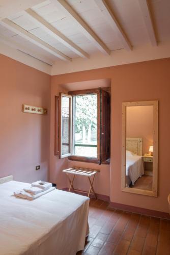 a bedroom with a bed and a large mirror at Albergo Villa San Michele in Greve in Chianti