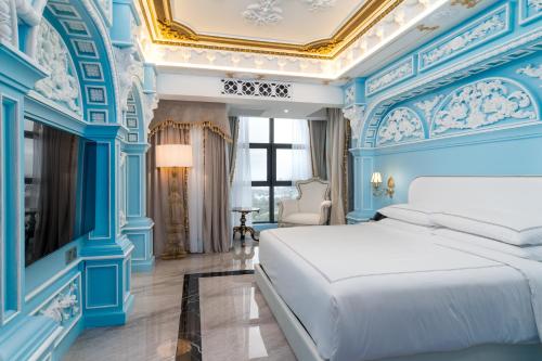 a bedroom with blue walls and a white bed at arte by Thomas Chan in Kuala Lumpur