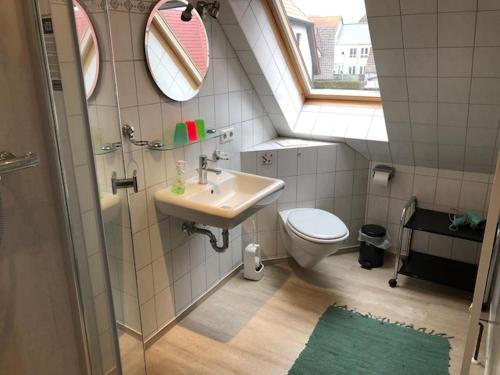 bagno con lavandino, servizi igienici e finestra di Birkenstr_17 A OG a Zingst