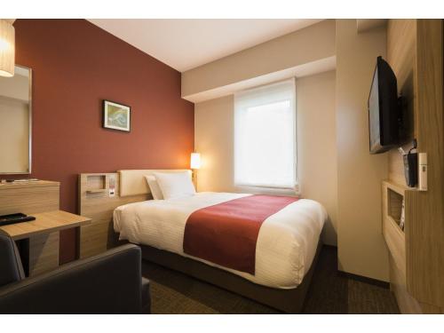 a hotel room with a bed and a window at KEIKYU EX INN Keikyu Kawasaki-Station in Kawasaki