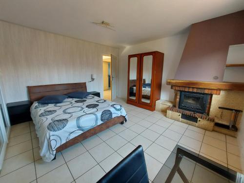 une chambre avec un lit et une cheminée dans l'établissement Entre lac et montagne, proche centre de St Jorioz, spacieux et confortable appartement avec grande terrasse, à Saint-Jorioz