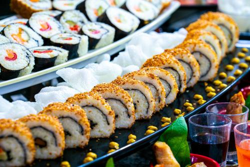 a display of sushi and other foods on trays at Bera Alanya Hotel - Halal All Inclusive in Konaklı