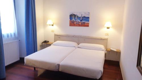 a hotel room with two beds and two lamps at Hotel Zarauz in Zarautz