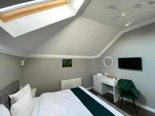 1 dormitorio con 1 cama, escritorio y TV en Erbario House, en Bucarest