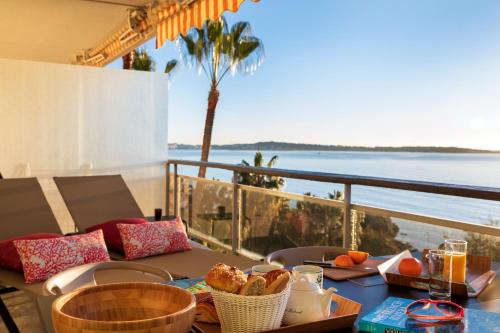 uma mesa com comida e vista para o oceano em Super Cannes Sea Side em Vallauris