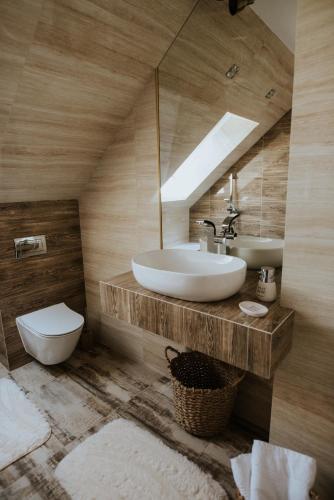 a bathroom with a sink and a toilet and a mirror at Wzgórze Marzeń in Zembrzyce
