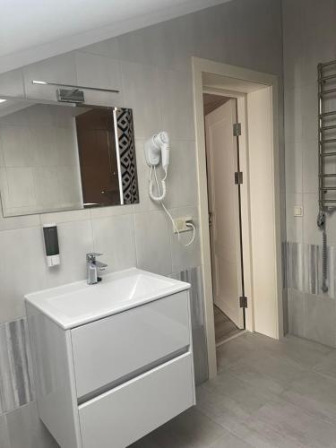 a bathroom with a white sink and a phone at Villa Затишна de luxe in Mykulychyn
