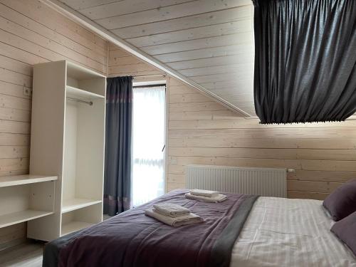 a bedroom with a bed and a window at Villa Затишна de luxe in Mykulychyn