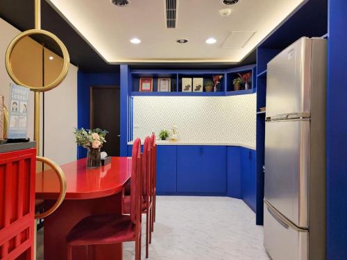 a blue kitchen with a red table and a refrigerator at Talmud Hotel Gongyuan in Taichung