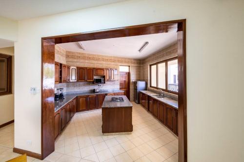 a large kitchen with wooden cabinets and a large island at Luxury 3BR Nyali Beachfront Apartment - 3 Min Walk in Mombasa