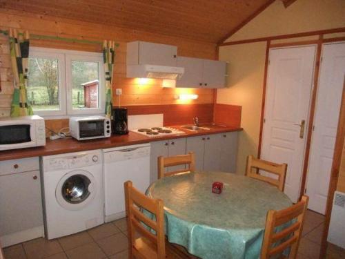 eine Küche mit einem Tisch, einer Spüle und einer Mikrowelle in der Unterkunft Chalet edelweiss 35 in Mélisey