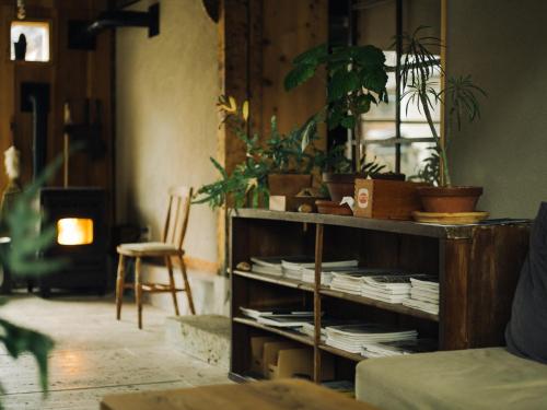 a room with a shelf with plants and a chair at Hostel Saruya in Fujiyoshida