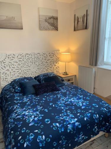 a bedroom with a bed with a blue comforter at Lyon City Home's Bed & Breakfast in Villeurbanne