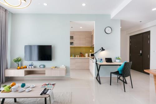 a kitchen and living room with a table and a tv at SOHO Suites - Saigon Central, 5-Min-To-Bui Vien Street in Ho Chi Minh City