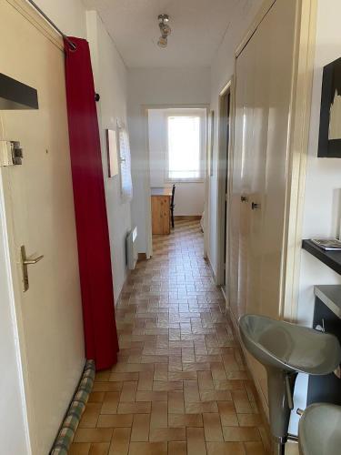 a hallway with a red door and a sink at Apartment Viktor II in Vinon-sur-Verdon