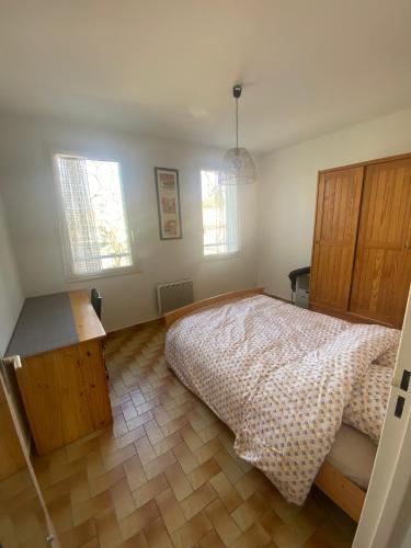 a bedroom with a bed and a desk and two windows at Apartment Viktor II in Vinon-sur-Verdon
