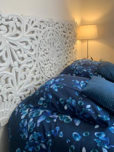 a bedroom with a bed with blue and white sheets at Lyon City Home's Bed & Breakfast in Villeurbanne