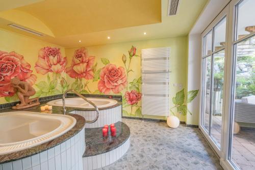 a bathroom with a tub and a flower mural at Top FeWo groß,2 Schlafzimmer Südbalkon mit Saunanutzung in Wertach