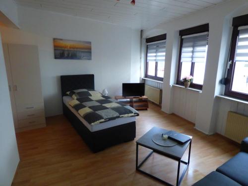 ein Wohnzimmer mit einem Bett und einem Sofa in der Unterkunft Gästehaus-City in Helmstedt
