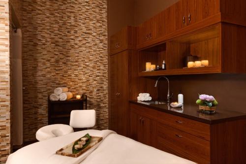a room with a bed and a sink and a table at Fairmont Kea Lani, Maui in Wailea