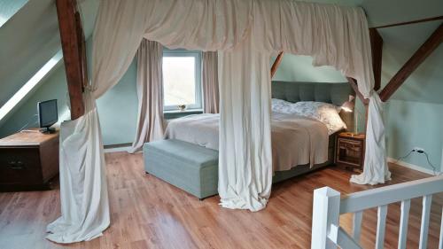 a bedroom with a canopy bed and a window at Maries Haus in Schaalby