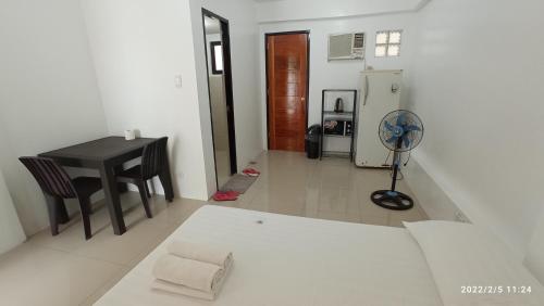 マニラにあるThe Palines Aparthotel near Palazzo Verde Evia Alabangのテーブルと冷蔵庫のあるリビングルーム