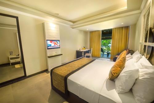 a bedroom with a large bed and a television at Earl's Reef in Bentota