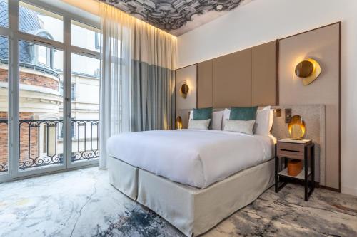 En eller flere senge i et værelse på InterContinental Paris Champs Elysées Etoile, an IHG Hotel