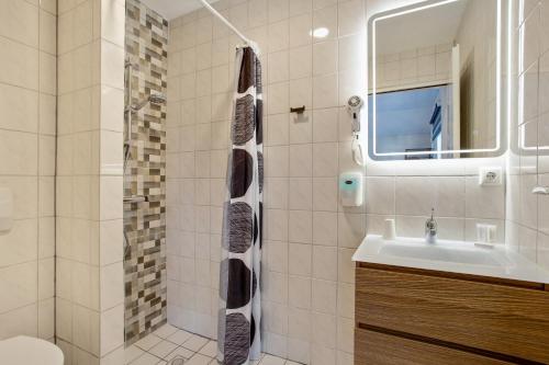 
a bathroom with a shower and a sink at Hotel de Logerij Renesse in Renesse
