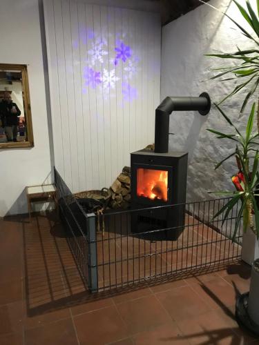 a wood stove in a room with a wall at Ferienanlage Achtern Diek in Thalingburen