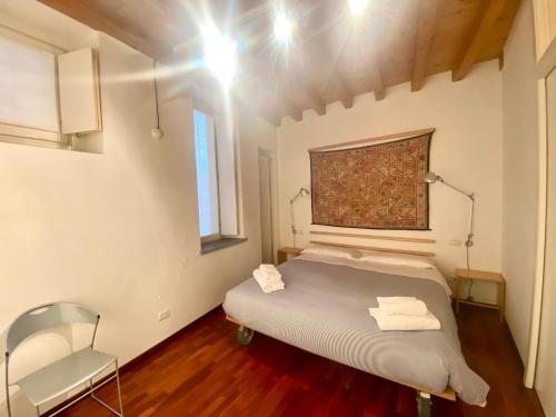 a bedroom with a bed and a chair in it at CASA HERMES in Bergamo