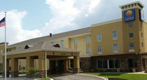 ein Hotel mit einer Flagge davor in der Unterkunft Comfort Inn & Suites Dothan East in Dothan