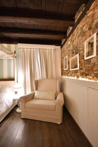 a living room with a chair and a bed at Al Palazzetto in Udine