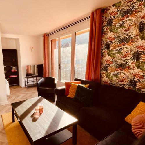 ein Wohnzimmer mit einem Sofa und einem Tisch in der Unterkunft L'Ekrin des Cimes in Le Mont-Dore